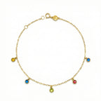 Gold anklet with colorful gemstones on a white background