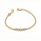 Gold bracelet with multicolored beads on a white background