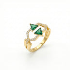 Gold ring with green gemstones on a white background