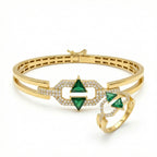 Gold bracelet and ring with green gemstones on a white background