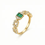 Gold ring with emerald and diamonds on a white background