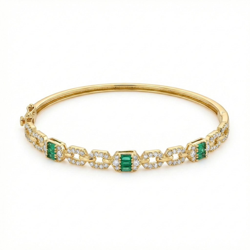 Gold bracelet with emerald and diamond accents on a white background