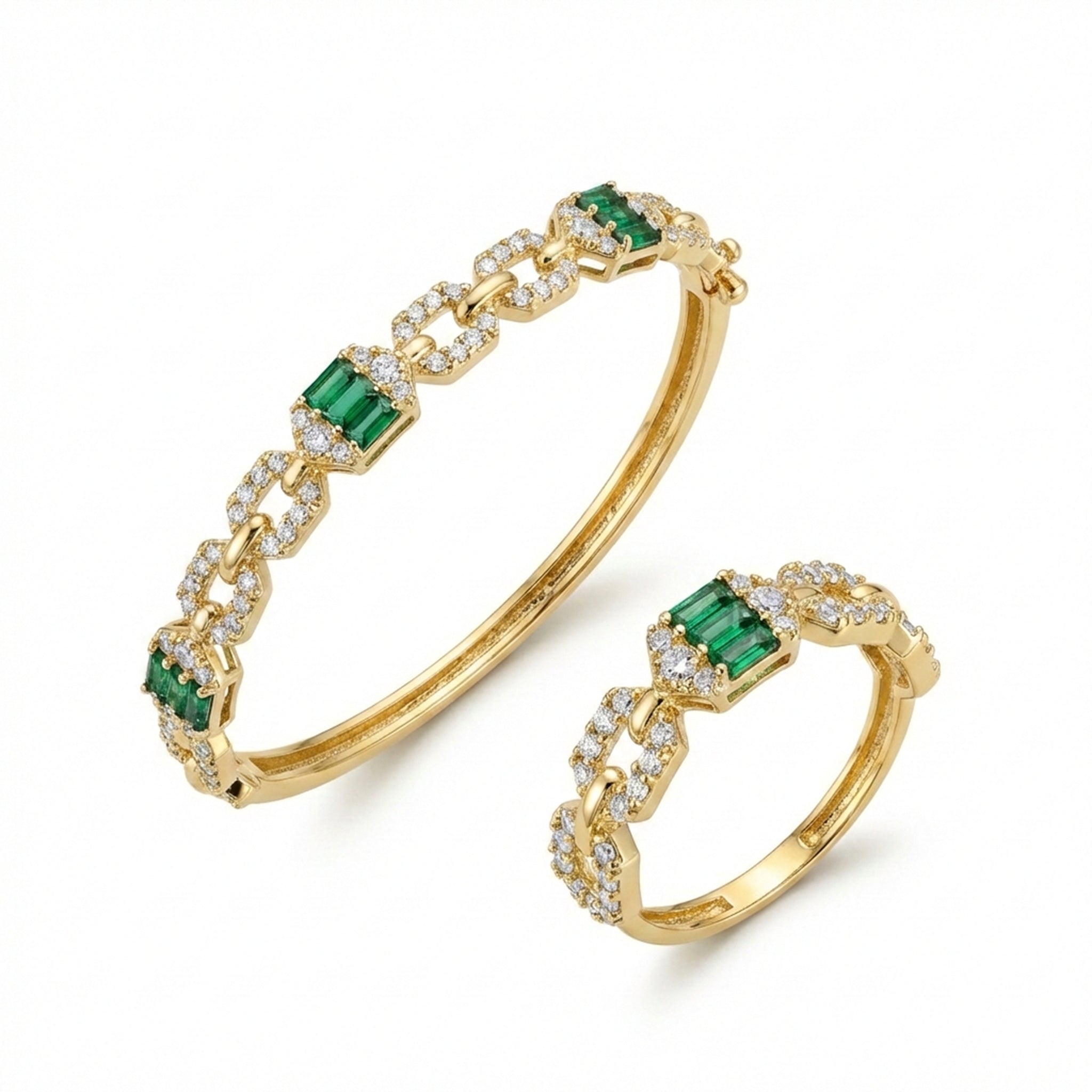 Gold bracelet and ring set with emeralds and diamonds on a white background