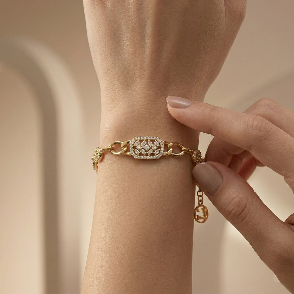 A high-end close-up of a Lazurde 18k yellow gold bracelet on a wrist, highlighting the shimmering diamond-like detail of the geometric centerpiece as a hand gently touches the wrist in a warm, luxury lifestyle setting.