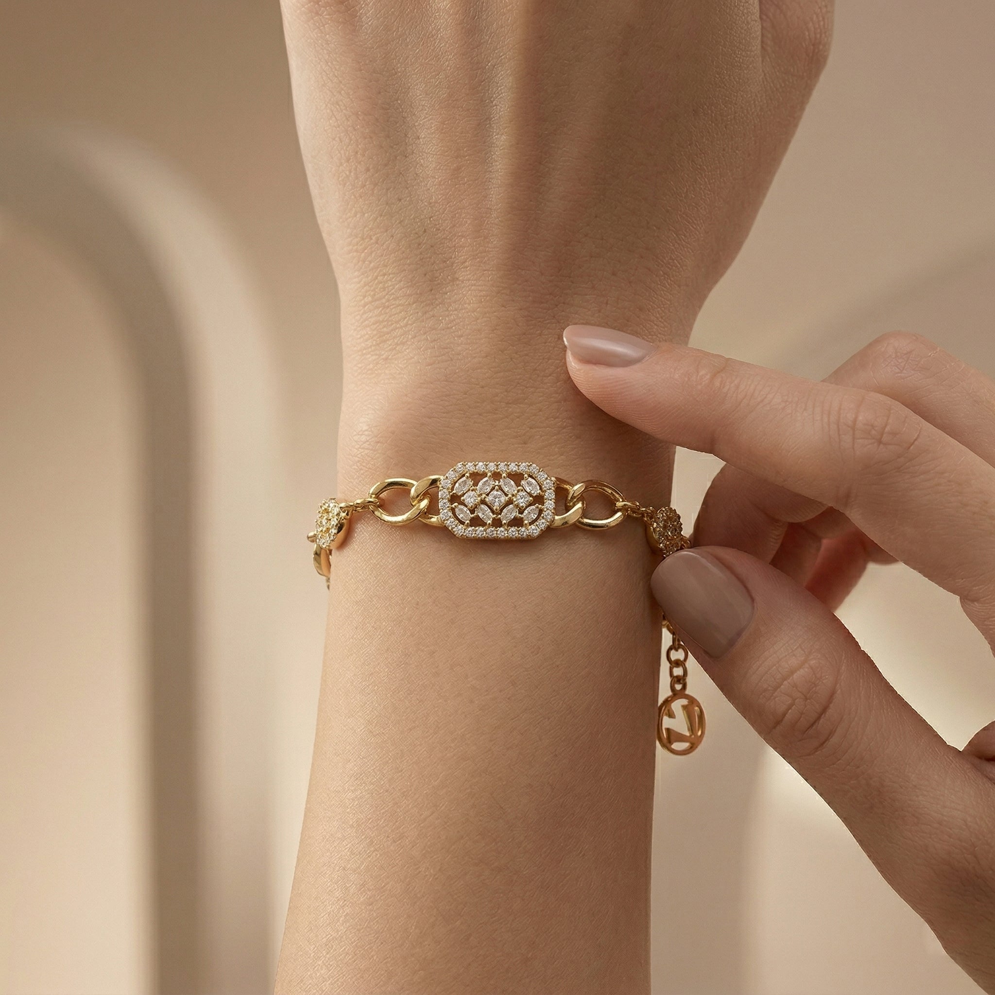 A high-end close-up of a Lazurde 18k yellow gold bracelet on a wrist, highlighting the shimmering diamond-like detail of the geometric centerpiece as a hand gently touches the wrist in a warm, luxury lifestyle setting.