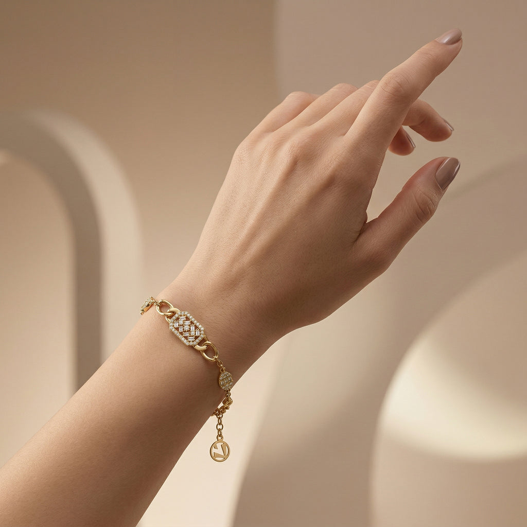Editorial-style luxury photo of a Lazurde 18k yellow gold stone-set bracelet worn on a feminine wrist with a sculptural hand pose, set against a soft nude-beige gradient background with diffused lighting.
