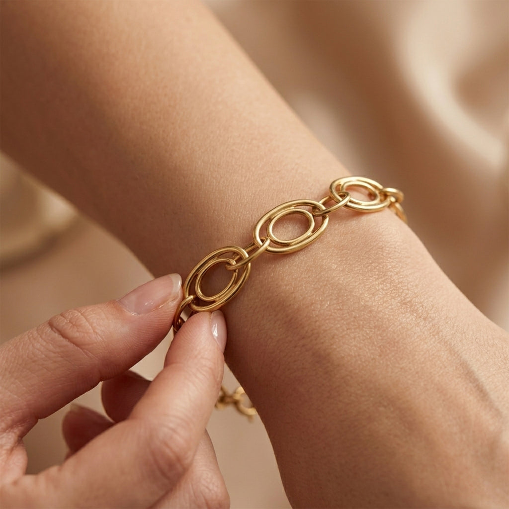 Luxury close-up of the Dreams 18k yellow gold bracelet being gently touched on a wrist.