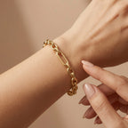 A luxury 4K close-up of the Wassef 18k yellow gold Gourmet bracelet on a wrist, featuring a gentle touch to showcase the refined texture and high-shine gold links.