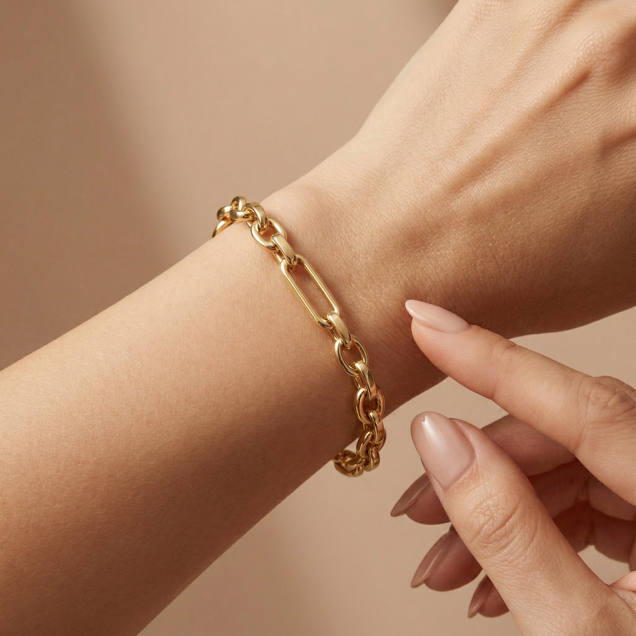 A luxury 4K close-up of the Wassef 18k yellow gold Gourmet bracelet on a wrist, featuring a gentle touch to showcase the refined texture and high-shine gold links.