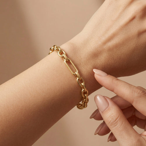 A luxury 4K close-up of the Wassef 18k yellow gold Gourmet bracelet on a wrist, featuring a gentle touch to showcase the refined texture and high-shine gold links.