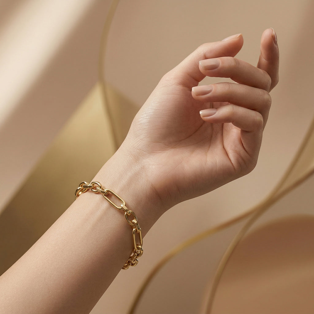 Wassef 18k yellow gold Gourmet bracelet styled on a feminine wrist with an elegant sculptural hand pose against a soft nude-beige editorial background.