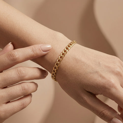 Luxury 4K close-up of the Wassef 18k yellow gold Gourmet bracelet on a wrist, featuring a gentle touch to highlight the polished gold texture.