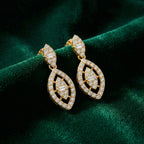Gold earrings with diamond accents on a green velvet background