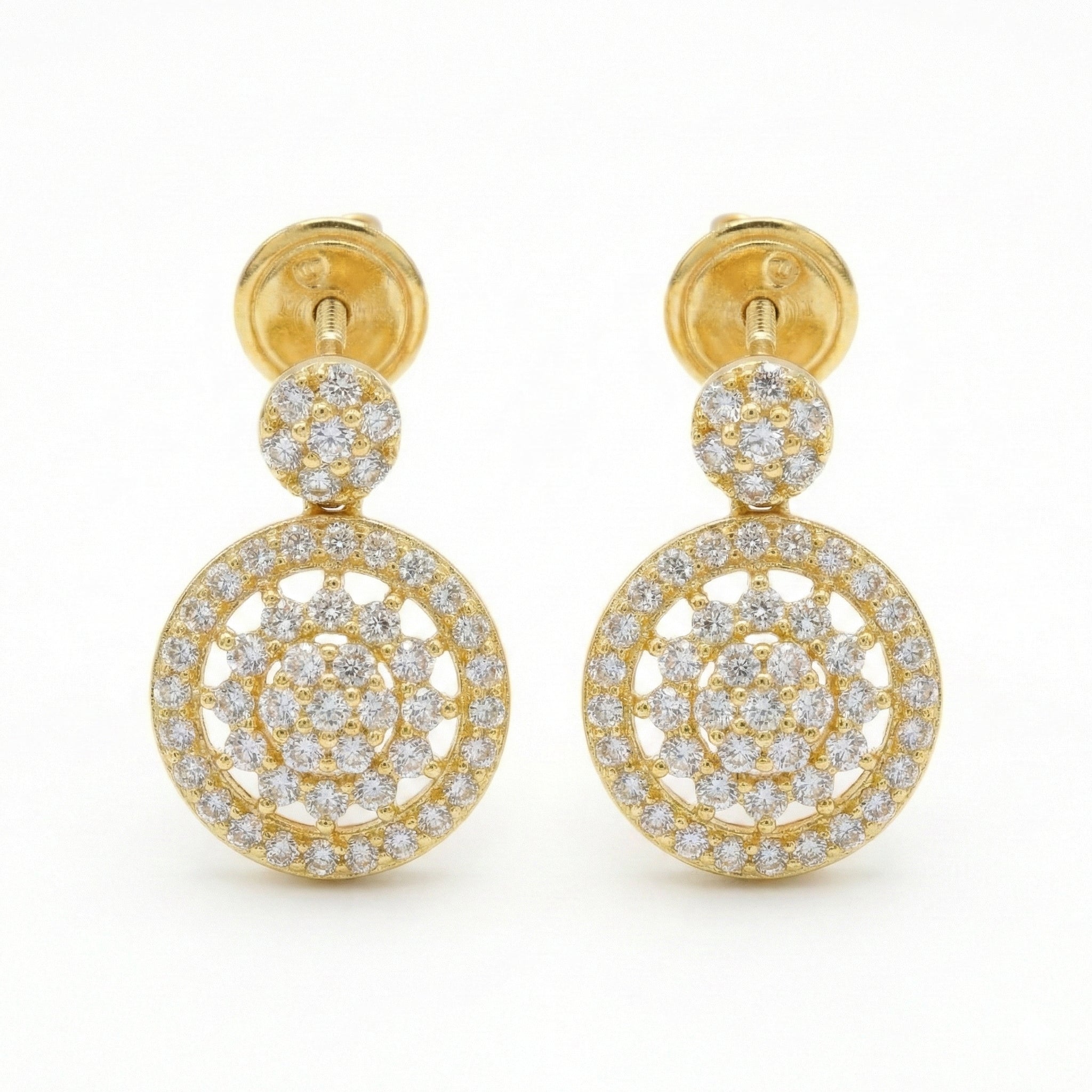 Gold earrings with circular designs and clear stones on a white background