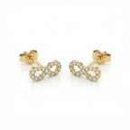 Gold infinity symbol earrings with clear stones on a white background