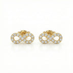 Gold infinity symbol earrings with clear gemstones on a white background