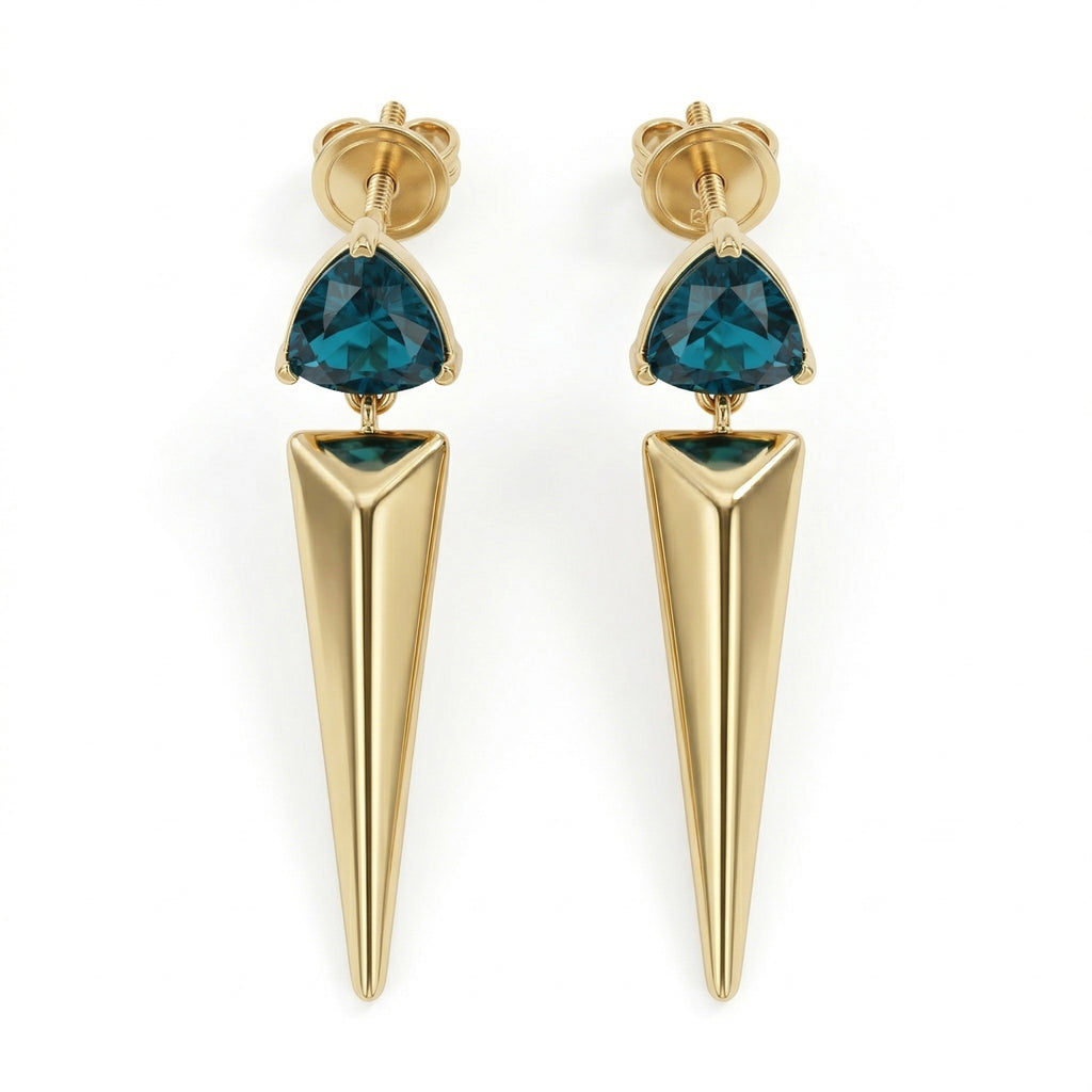A pair of Lazurde 18k yellow gold earrings featuring a trillion-cut teal gemstone set above a long, polished gold spike pendant, isolated on a pure white background in a 4k product shot.