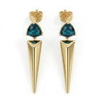 A pair of Lazurde 18k yellow gold earrings featuring a trillion-cut teal gemstone set above a long, polished gold spike pendant, isolated on a pure white background in a 4k product shot.