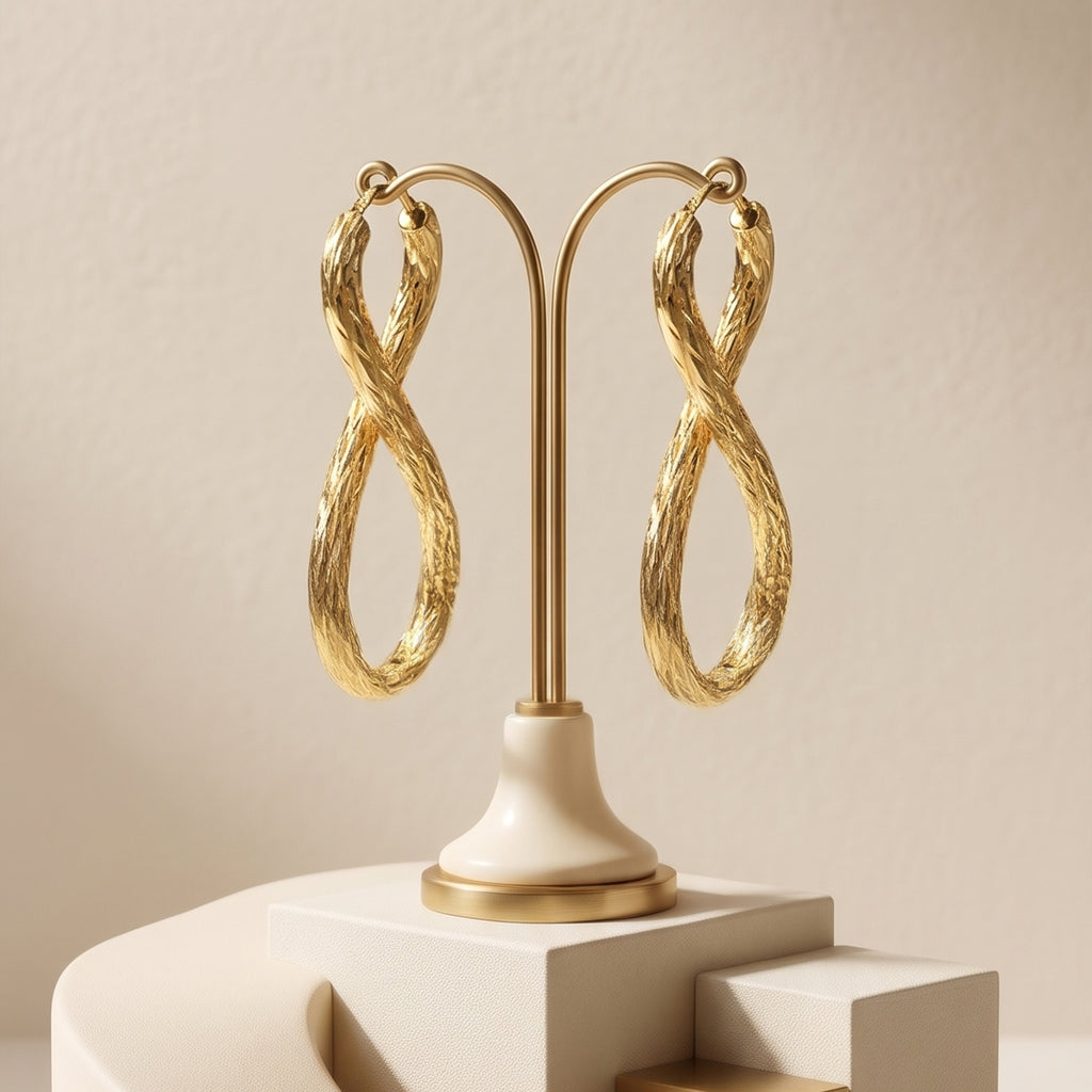 UNO brand 18k yellow gold infinity earrings displayed on luxurious neutral pedestals.
عرض فاخر لحلق دهب عيار 18 تصميم إنفينيتي من أونو على استاندات راقية
