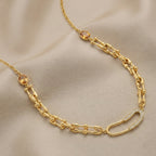 Gold chain necklace on a beige fabric background