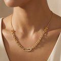 Gold necklace with gemstones on a person wearing a white outfit