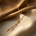 Gold necklace with pendant on a beige fabric background