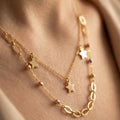 Gold necklace with star pendants on a person's neck