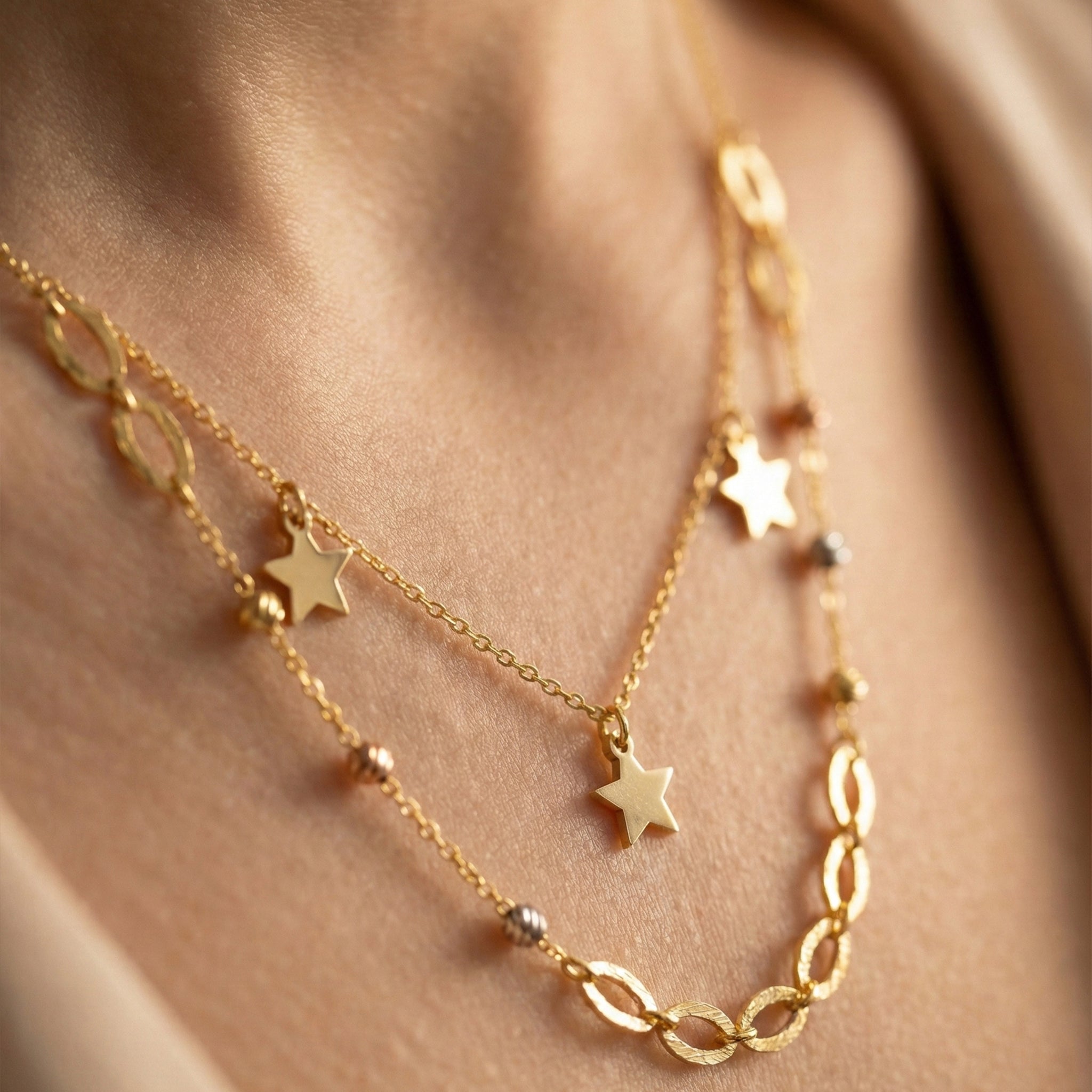Gold necklace with star pendants on a person's neck