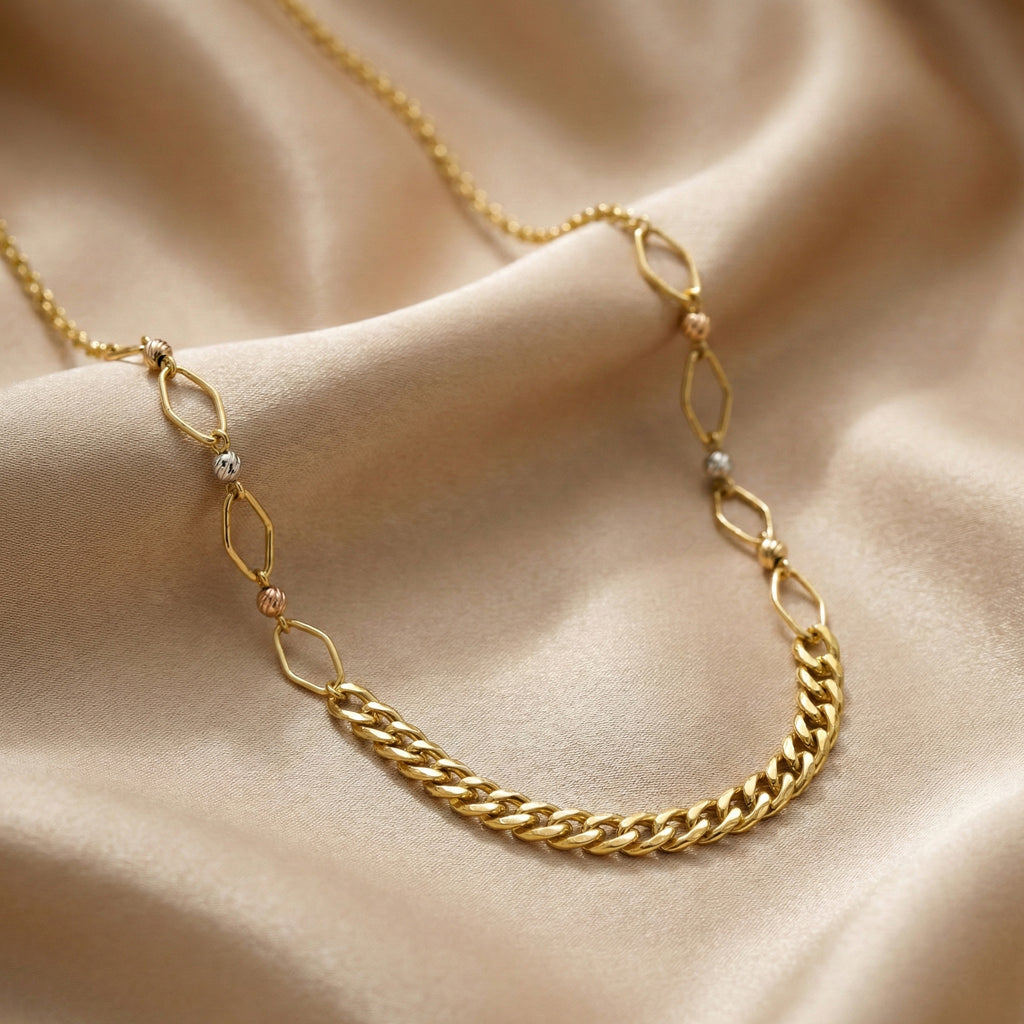Gold chain necklace on a beige fabric background