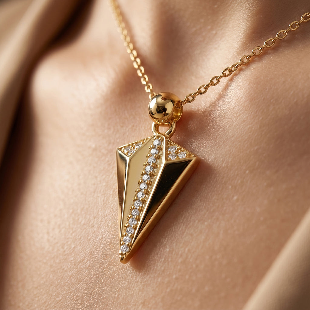 Extreme close-up of a King gold 18k yellow gold geometric pendant resting softly near a collarbone, highlighting the smooth metal texture and radiant pave diamond-like details.
لقطة مقربة جداً لقلادة كينج جولد (King gold) الهندسية من الذهب الأصفر عيار 18 تستقر بنعومة بالقرب من عظمة الترقوة، تبرز نعومة المعدن وتفاصيل الفصوص البراقة.