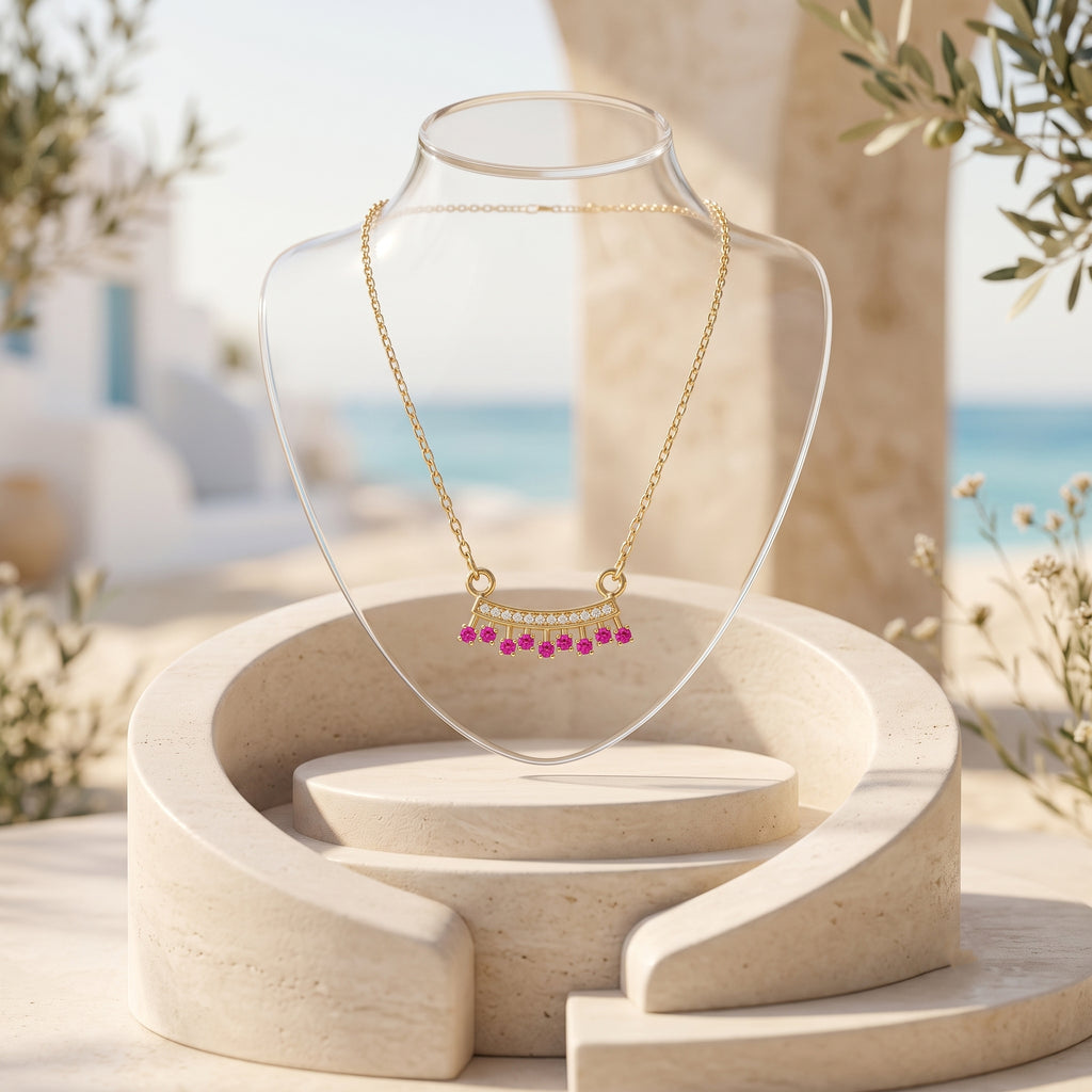 18K gold necklace with fuchsia pink gemstone pendant on a clear acrylic bust stand, set against a Mediterranean-style background.
سلسلة ذهب عيار ١٨ مع دلاية بأحجار فوشيا بينك على ستاند عرض أكريليك شفاف، في خلفية مستوحاة من أجواء البحر المتوسط.
