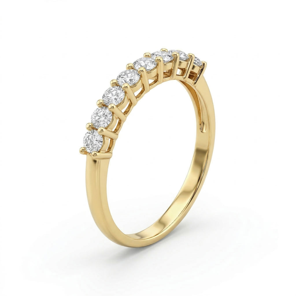 Angled profile of the Fine Gold 18k yellow gold wedding promise ring from The Forever Edit category, showcasing a delicate band set with nine brilliant stones against a pure white background.