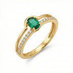 Gold ring with a green gemstone and diamond accents on a white background