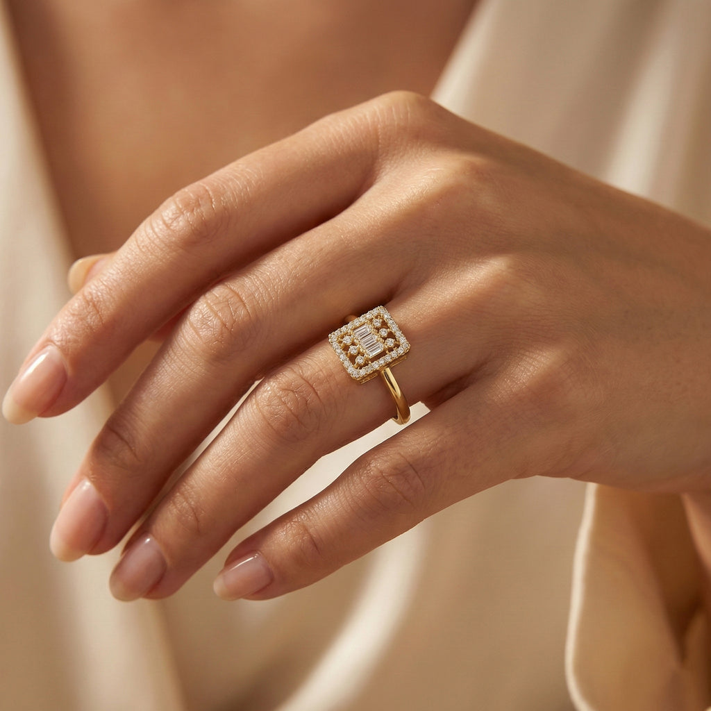 Gold ring with a diamond on a hand against a neutral background