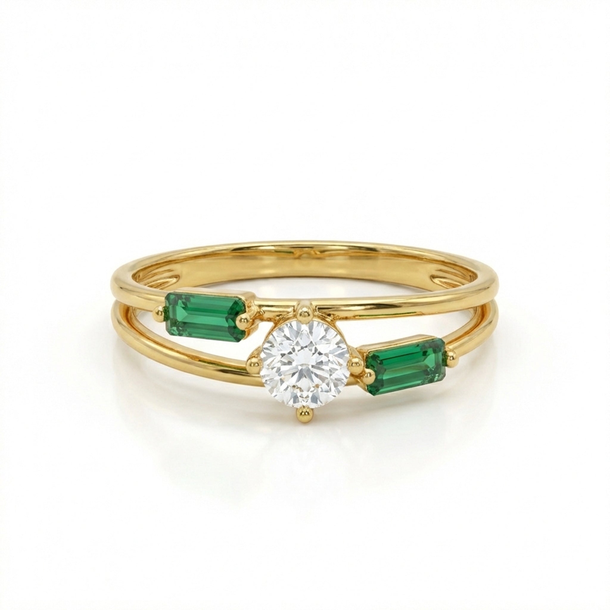 Gold ring with a diamond and emerald stones on a white background