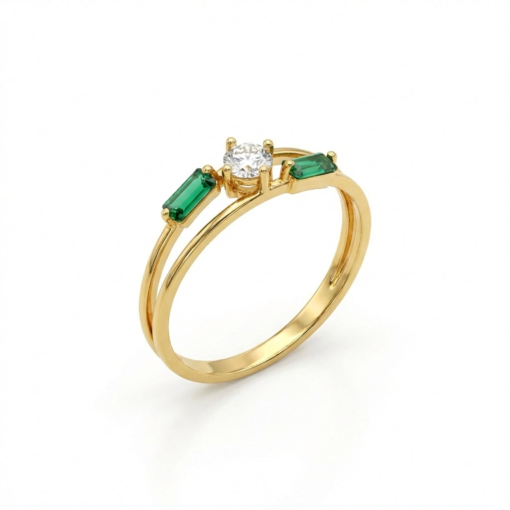 Gold ring with a central diamond and two emeralds on a white background