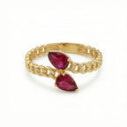 Gold chain ring with red gemstones on a white background