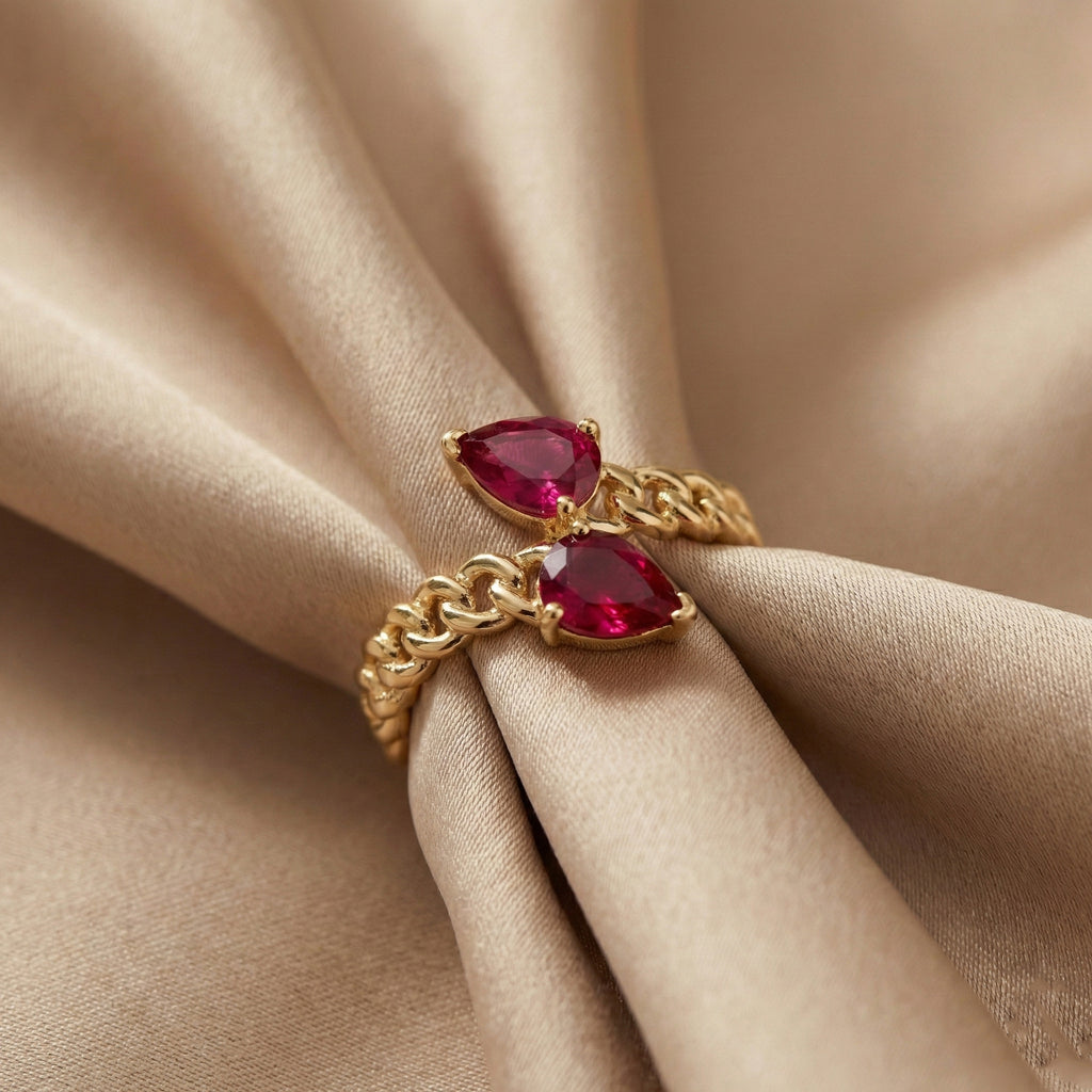 Gold ring with red gemstones on beige fabric