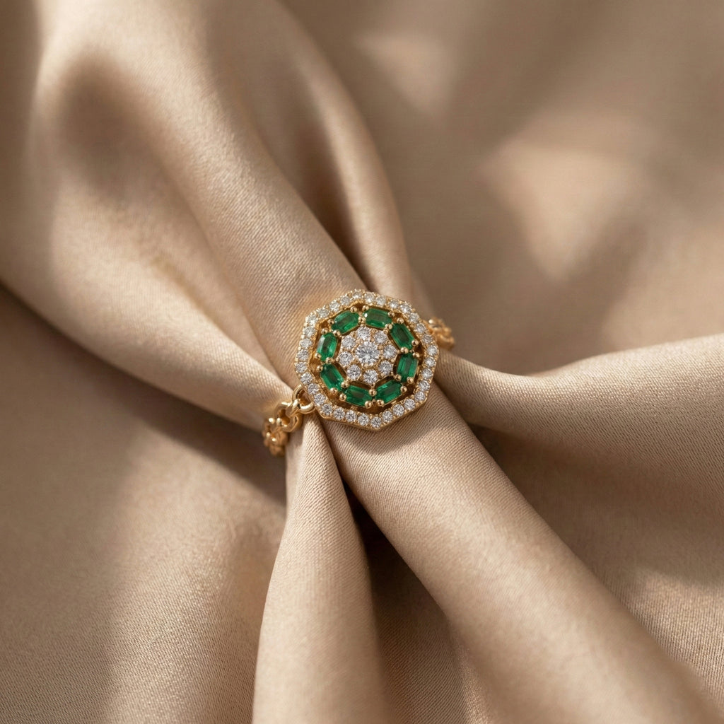 Gold ring with green gemstones on beige fabric