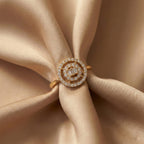 Gold ring with diamonds on a beige fabric background