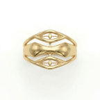 A top-down front view of an Andria 18k yellow gold ring lying flat on a pure white surface, showcasing the symmetrical, fluid cut-out patterns along the band.