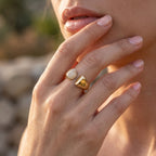 Close-up macro shot of the UNO 18k yellow gold open ring on a woman's hand, showcasing the sharp contrast between the radiant stones and polished gold.
صورة قريبة جداً لخاتم أونو المفتوح عيار 18 على إيد موديل، بتبرز التباين بين لمعة الدهب والفصوص.