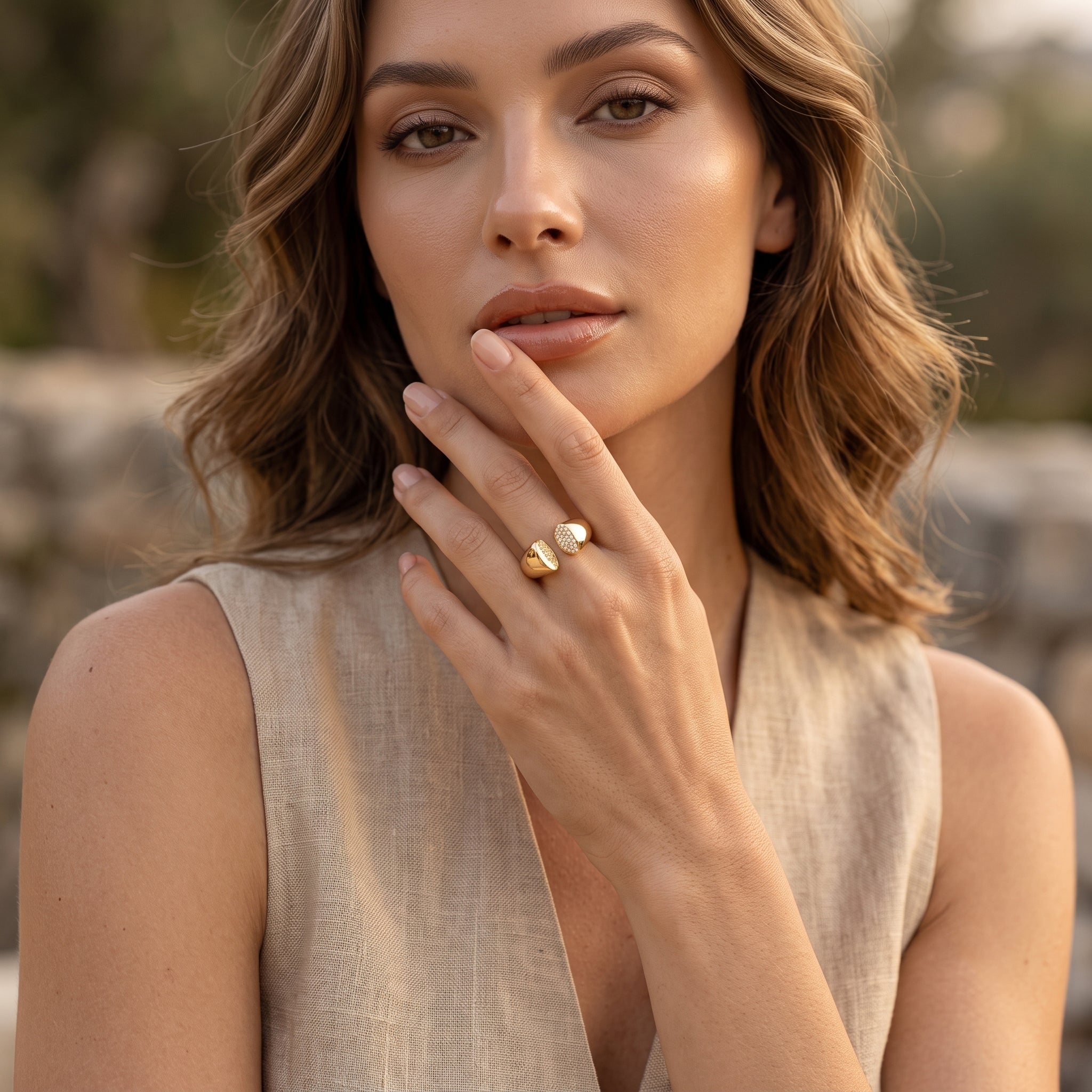 Elegant woman wearing the UNO 18k yellow gold asymmetric open ring outdoors in soft golden sunlight, highlighting the smooth and stone-set details.
موديل أنيقة لابسة خاتم أونو المفتوح دهب عيار 18 في إضاءة شمس طبيعية بتبين تفاصيل الدهب السادة والفصوص.