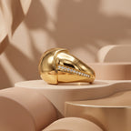 UNO 18k yellow gold sculptural bombe ring elegantly displayed on modern beige curved pedestals under soft luxury lighting.
خاتم أونو بومبيه دهب عيار 18 معروض على قواعد منحنية بتصميم مودرن وألوان بيج ناعمة.