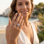 Lifestyle portrait of a woman in an ivory dress wearing the 10.27g Egypt Gold 18k yellow gold Luminous Crown Twin Rings on a Mediterranean coast.	عارضة أزياء ترتدي خواتم توينز التاج المضيء ذهب أصفر عيار 18 بوزن 10.27 جرام من إيجيبت جولد في مشهد صيفي ساحر على ساحل البحر.