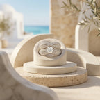 Luxury product photography of the L'azurde 18k white gold twin ring set displayed on an architectural travertine pedestal.	تصوير منتج فاخر لطقم خواتم توينز ذهب أبيض عيار 18 من لازوردي معروض على قاعدة معمارية أنيقة.
