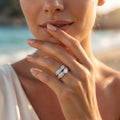 Macro beauty shot of a woman wearing the L'azurde 18k white gold twin ring set delicately posed near her face.	لقطة مقربة ليد عارضة ترتدي طقم خواتم توينز ذهب أبيض عيار 18 من لازوردي بجوار وجهها.