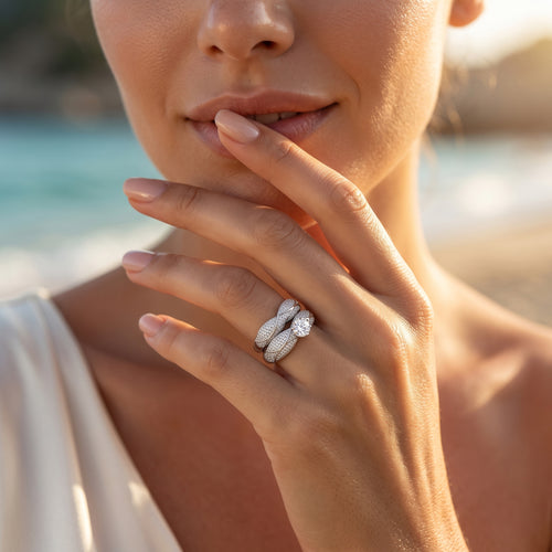 Macro beauty shot of a woman wearing the L'azurde 18k white gold twin ring set delicately posed near her face.	لقطة مقربة ليد عارضة ترتدي طقم خواتم توينز ذهب أبيض عيار 18 من لازوردي بجوار وجهها.