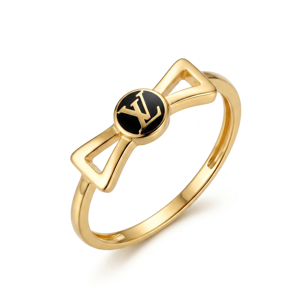 18k yellow gold bow ring with black enamel center by Lamar on a pure white background.	خاتم من الذهب الأصفر عيار 18 بتصميم فيونكة ومركز مينا أسود من لامار على خلفية بيضاء نقية.