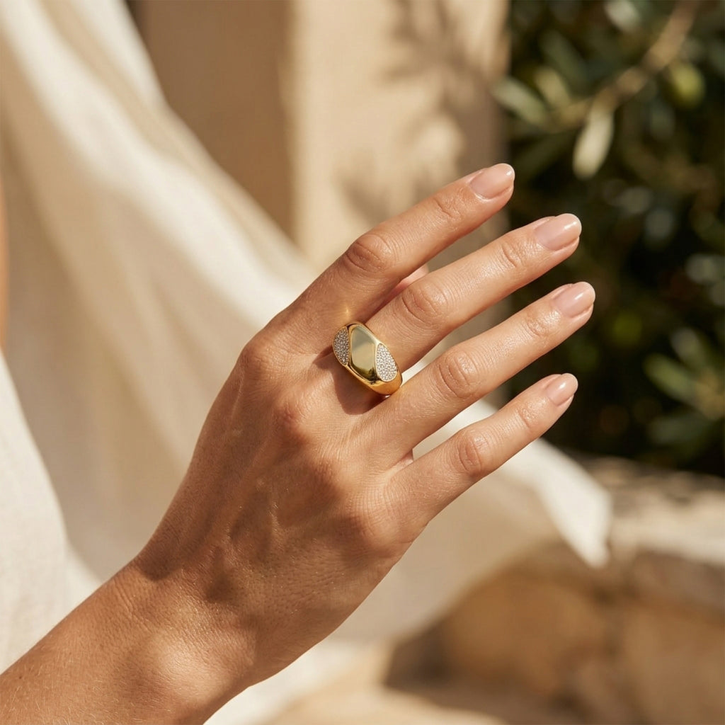 Close-up of a feminine hand gently moving through warm summer sunlight, wearing a 4.55g Fine Gold 18k yellow gold ring. صورة مقربة ليد أنثوية تتحرك بنعومة تحت ضوء شمس الصيف، وترتدي خاتم فاين جولد ذهب أصفر عيار 18 بوزن 4.55 جرام.